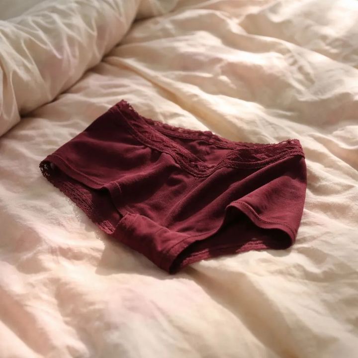 Plum boyshorts, worn, lying on a bed